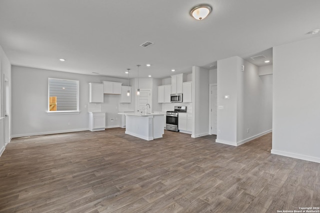 kitchen with white cabinetry, sink, hanging light fixtures, a kitchen island with sink, and appliances with stainless steel finishes