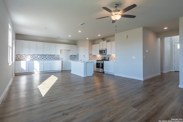 kitchen featuring white cabinets, dark hardwood / wood-style flooring, a center island with sink, and stainless steel appliances