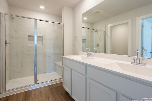 bathroom with vanity, hardwood / wood-style flooring, and a shower with door