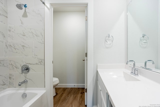 full bathroom with hardwood / wood-style flooring, vanity, toilet, and tiled shower / bath