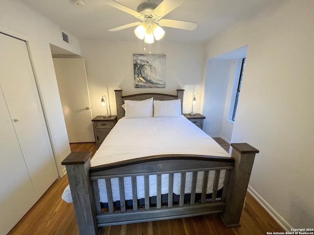 bedroom featuring ceiling fan, dark hardwood / wood-style flooring, and a closet