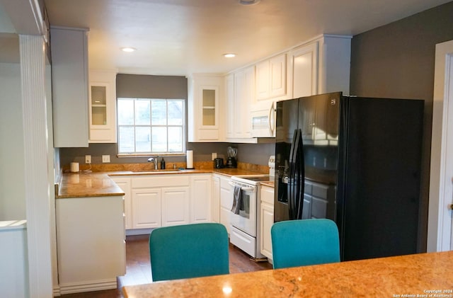 kitchen featuring white appliances, white cabinetry, and sink