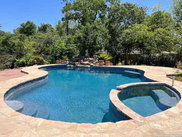 view of swimming pool featuring an in ground hot tub and a patio