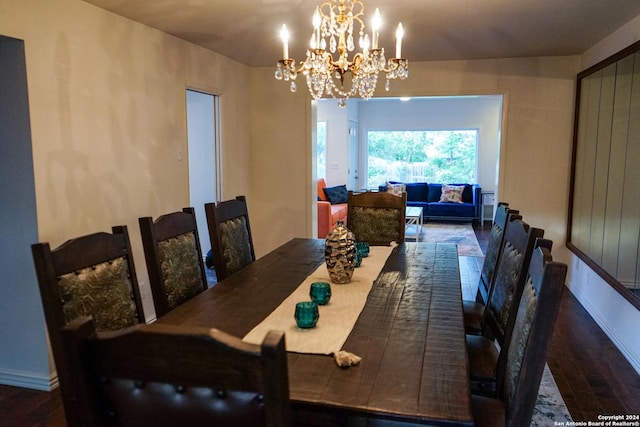 dining area featuring dark hardwood / wood-style flooring and an inviting chandelier