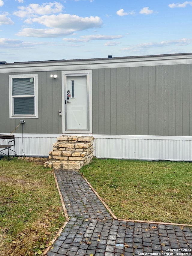 property entrance featuring a lawn