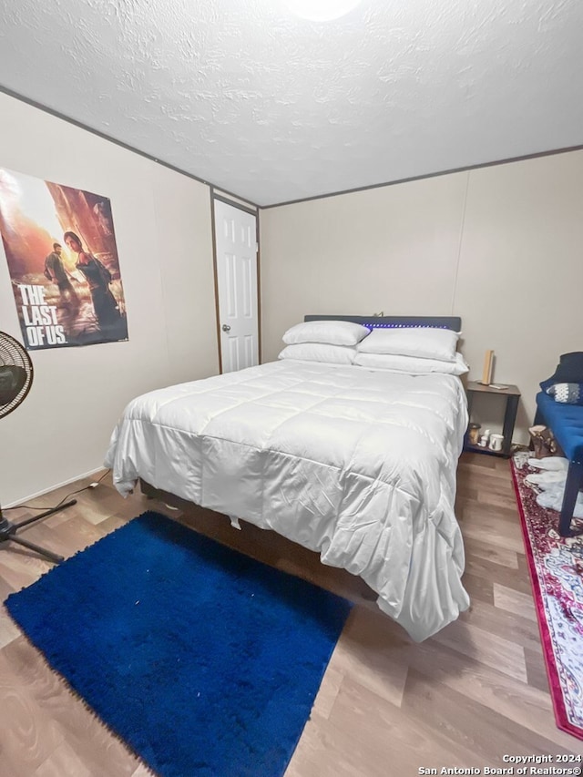 bedroom with wood-type flooring and a textured ceiling