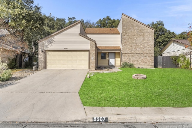 view of front of property featuring a garage, a front lawn, and a fire pit