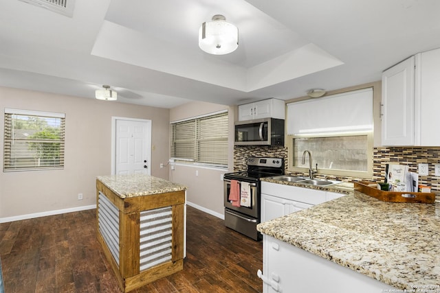 kitchen with a raised ceiling, white cabinetry, sink, and appliances with stainless steel finishes