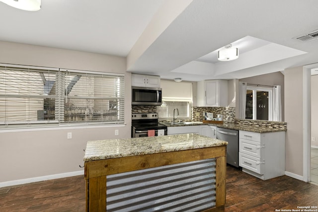 kitchen with a center island, white cabinets, stainless steel appliances, and sink