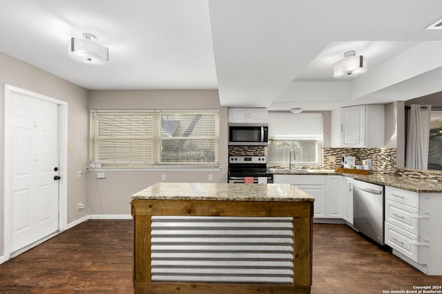 kitchen featuring tasteful backsplash, light stone counters, stainless steel appliances, white cabinets, and dark hardwood / wood-style floors