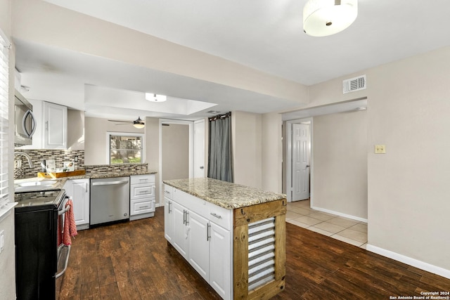 kitchen featuring white cabinets, sink, decorative backsplash, appliances with stainless steel finishes, and dark hardwood / wood-style flooring