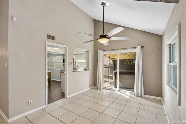 spare room with ceiling fan, a healthy amount of sunlight, light tile patterned floors, and lofted ceiling