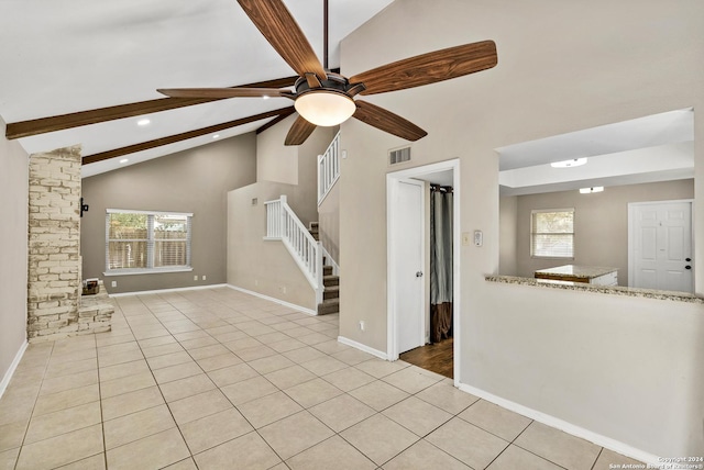 unfurnished living room with ceiling fan, light tile patterned floors, and vaulted ceiling