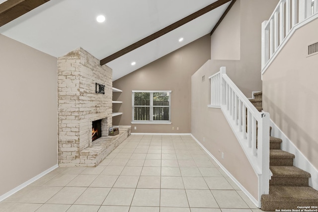 unfurnished living room featuring beamed ceiling, a stone fireplace, light tile patterned floors, and high vaulted ceiling