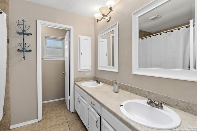 bathroom with tile patterned flooring, vanity, and a textured ceiling