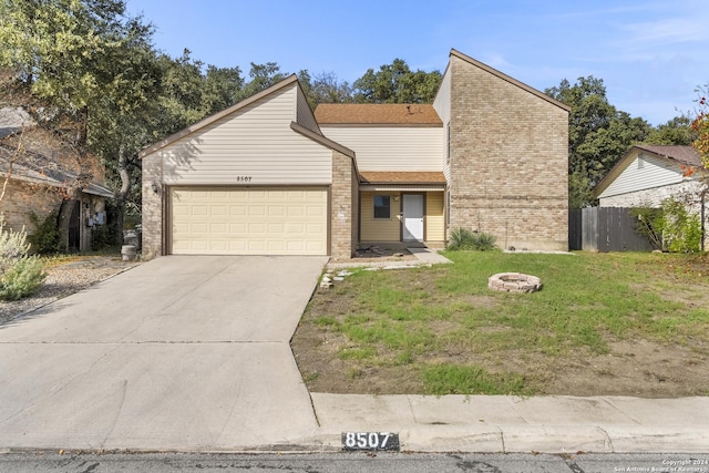 view of front facade with a garage, an outdoor fire pit, and a front lawn