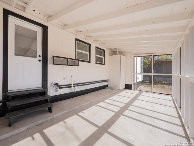 unfurnished sunroom featuring beam ceiling