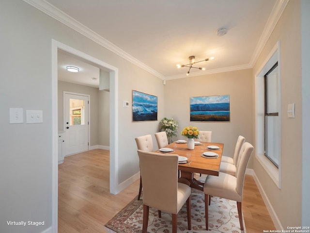 dining space featuring ornamental molding, a notable chandelier, and light wood-type flooring