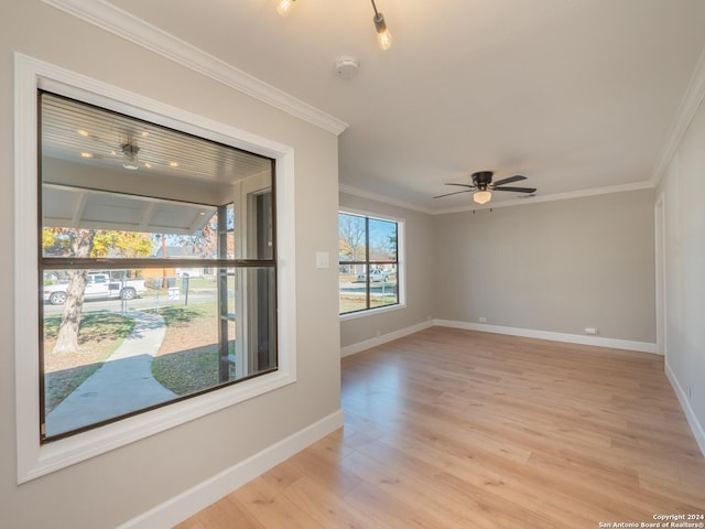 empty room with ceiling fan, crown molding, and light hardwood / wood-style flooring