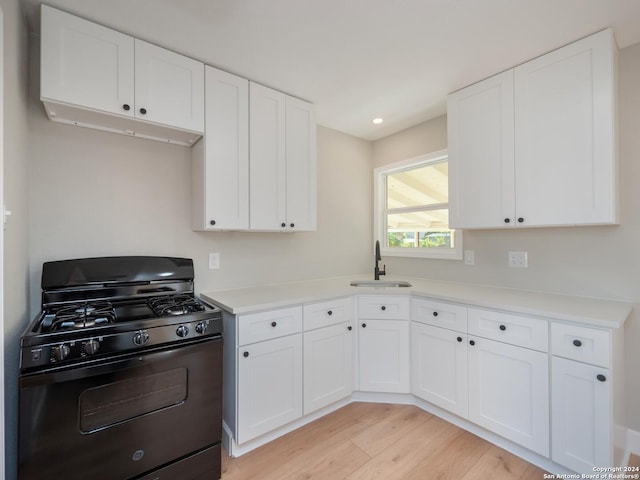 kitchen with white cabinetry, sink, black range with gas cooktop, and light wood-type flooring