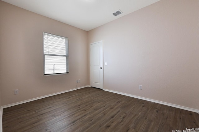 empty room with dark hardwood / wood-style flooring