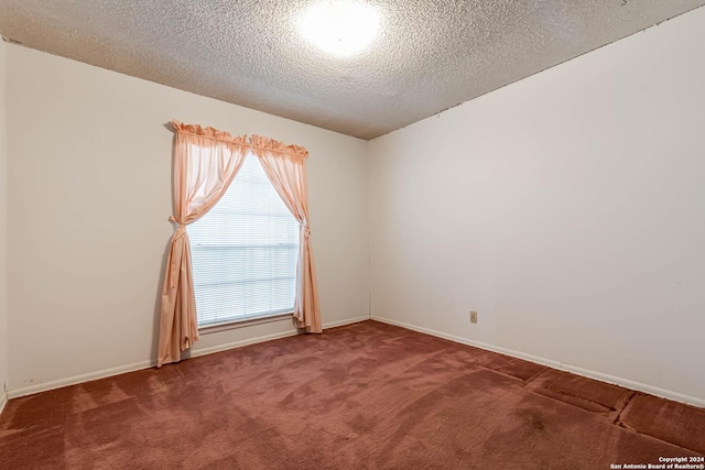 carpeted spare room with a textured ceiling