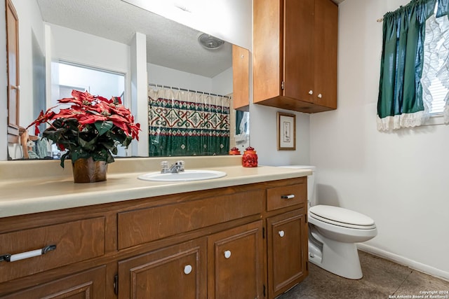 bathroom featuring vanity, a textured ceiling, and toilet