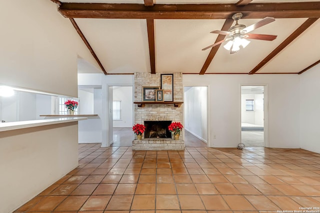 unfurnished living room featuring beam ceiling, light tile patterned floors, a brick fireplace, and ceiling fan