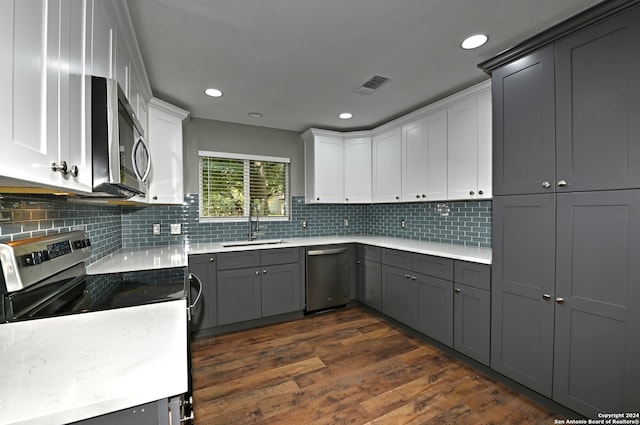 kitchen with sink, gray cabinets, tasteful backsplash, white cabinetry, and stainless steel appliances