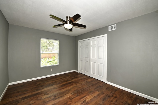 unfurnished bedroom featuring ceiling fan, a closet, and dark hardwood / wood-style floors