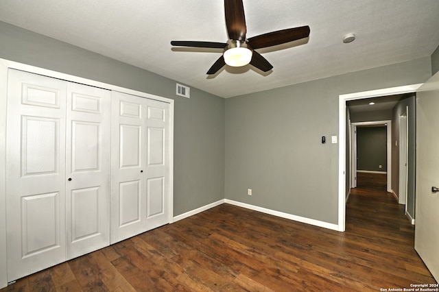 unfurnished bedroom with a closet, ceiling fan, and dark wood-type flooring