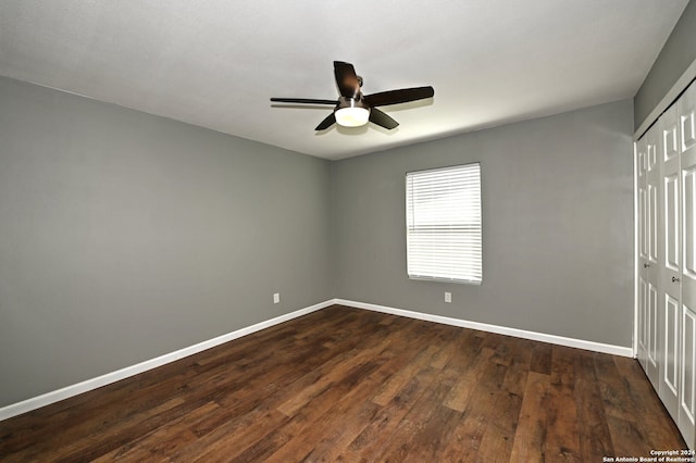 empty room with dark hardwood / wood-style floors and ceiling fan