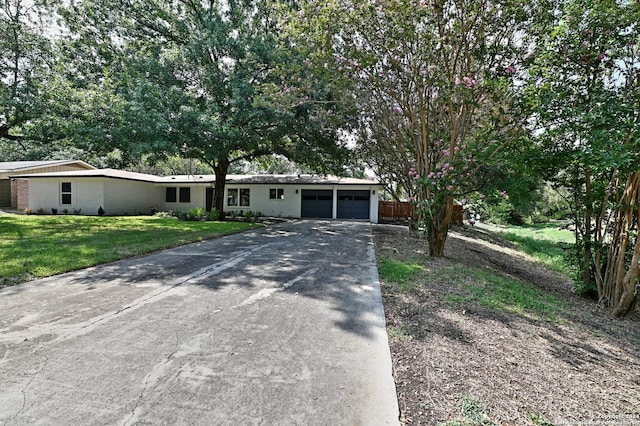 single story home featuring a garage and a front yard