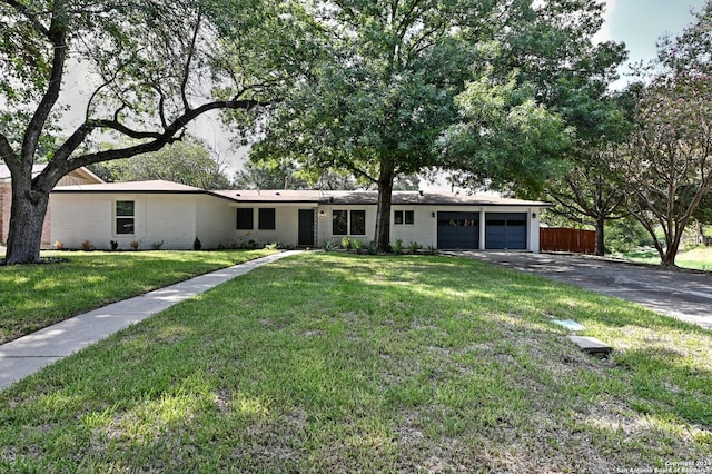 ranch-style house featuring a front lawn and a garage