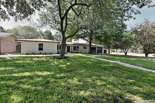 single story home featuring a front yard and a garage