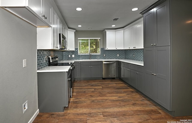 kitchen with sink, stainless steel appliances, tasteful backsplash, dark hardwood / wood-style flooring, and gray cabinets