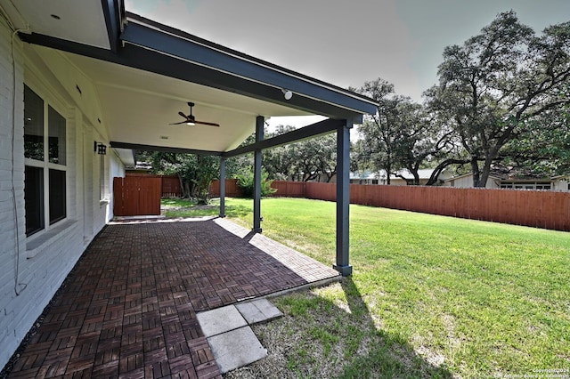 view of yard with ceiling fan and a patio