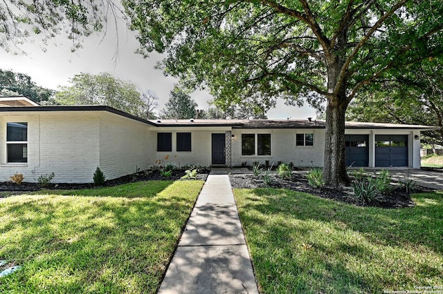 ranch-style house featuring a garage and a front lawn