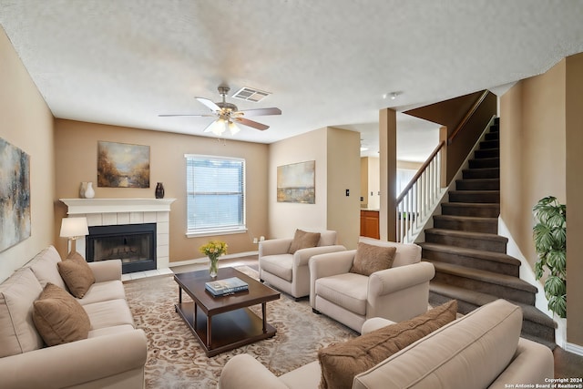 living room featuring ceiling fan and a fireplace