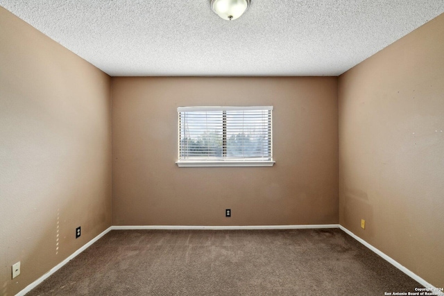 unfurnished room featuring a textured ceiling and carpet floors