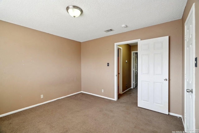 unfurnished room featuring carpet flooring and a textured ceiling