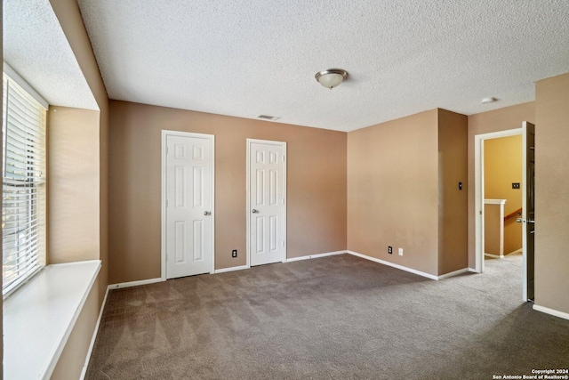 unfurnished bedroom with carpet and a textured ceiling