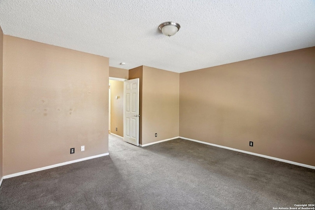 unfurnished room with dark colored carpet and a textured ceiling