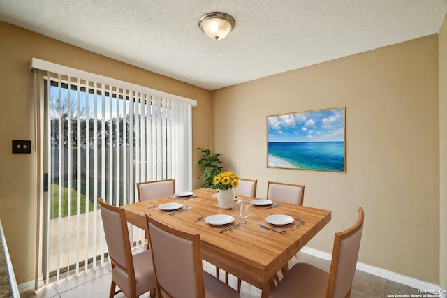 dining area with a textured ceiling and tile patterned floors