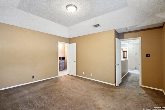 empty room featuring carpet, a textured ceiling, and vaulted ceiling