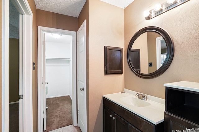 bathroom featuring tile patterned flooring, a textured ceiling, and vanity