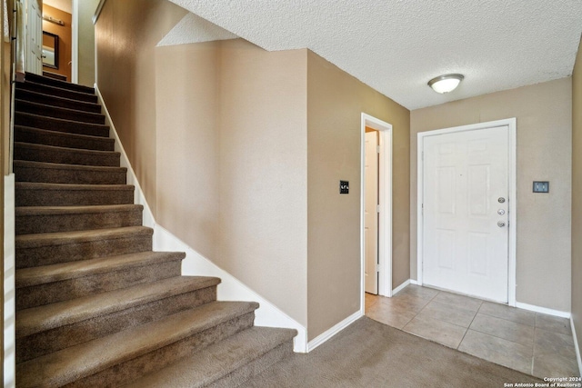 tiled foyer entrance with a textured ceiling