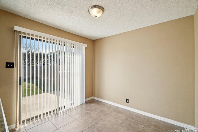 empty room featuring light tile patterned floors and a textured ceiling