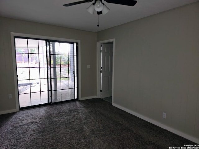 spare room featuring ceiling fan and dark colored carpet