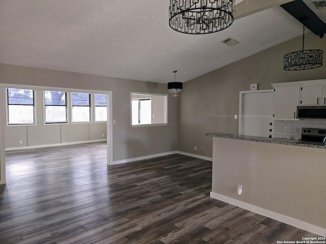 unfurnished living room with an inviting chandelier, vaulted ceiling, dark hardwood / wood-style floors, and a textured ceiling